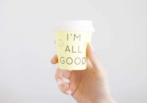 Une tasse à café avec l'inscription 'I'm all good', symbolisant la sérénité et la sécurité apportées par une prévoyance freelance adaptée.