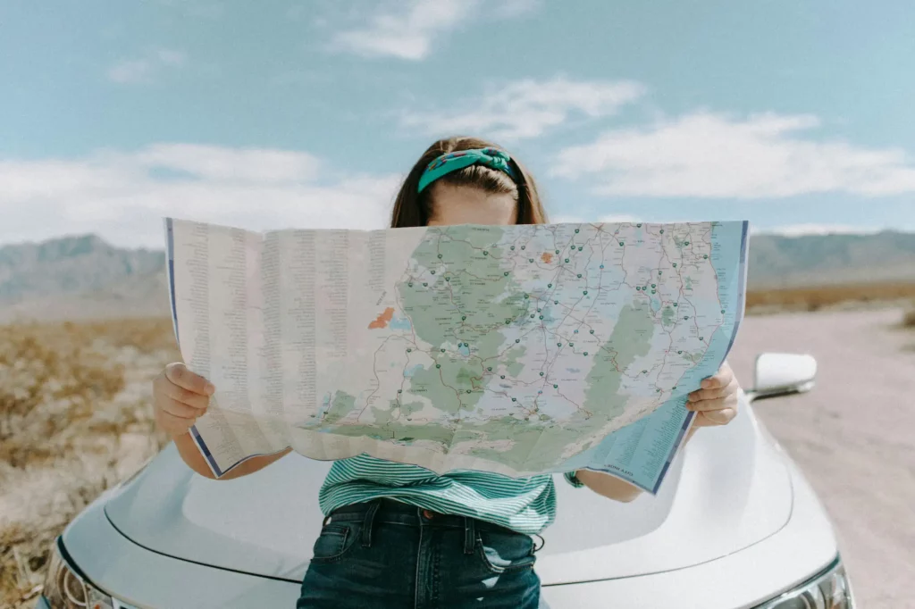 Femme entrepreneure examinant une carte routière, cherchant la bonne direction pour lancer sa micro-entreprise.